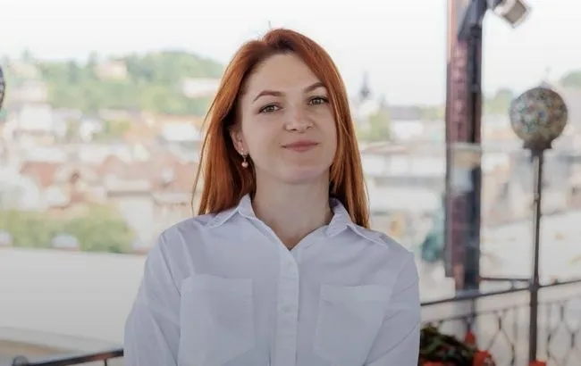 Мар'яна Мамонова в білій сорочці на тлі міста